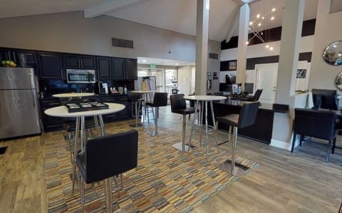 Sitting area with Tables, Chairs, Hardwood Inspired Floor, Carpet, Refrigerators and Black Cabinents